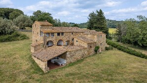 A stone building with a tiled roof, arched windows, and a covered patio area. - In The Heart Of Chianti, Pool, Wifi, View (Lilliano)