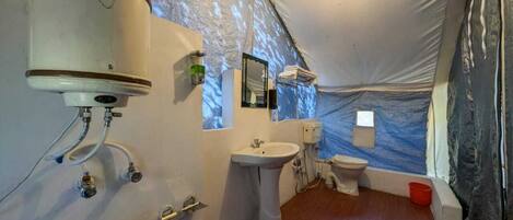 Un bagno in tenda piccolo e luminoso, con lavandino, WC e zona doccia.