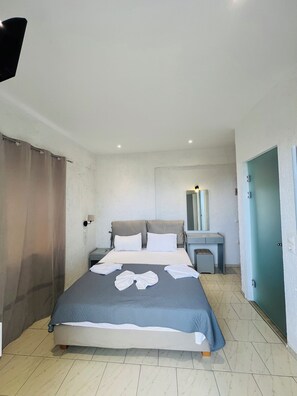 A hotel room with a bed, bedside table, and a desk with a chair. - Mark Hotel (Heraklion)