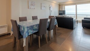 A dining area with a table set for six, a sofa, and a TV. - Family spot by the coastal trails (MIDDELKERKE)