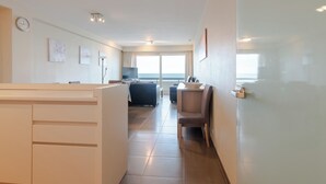 A modern hotel room with a large bed, a desk, and a view of the sea. - Family spot by the coastal trails (MIDDELKERKE)