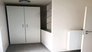 Ein Zimmer mit Schrank, Heizkörper und einer halb geöffneten Tür.