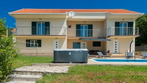 A two-story house with a swimming pool, outdoor seating, and a hot tub. - Villa Anatea by Villas Guide (Cista Provo)