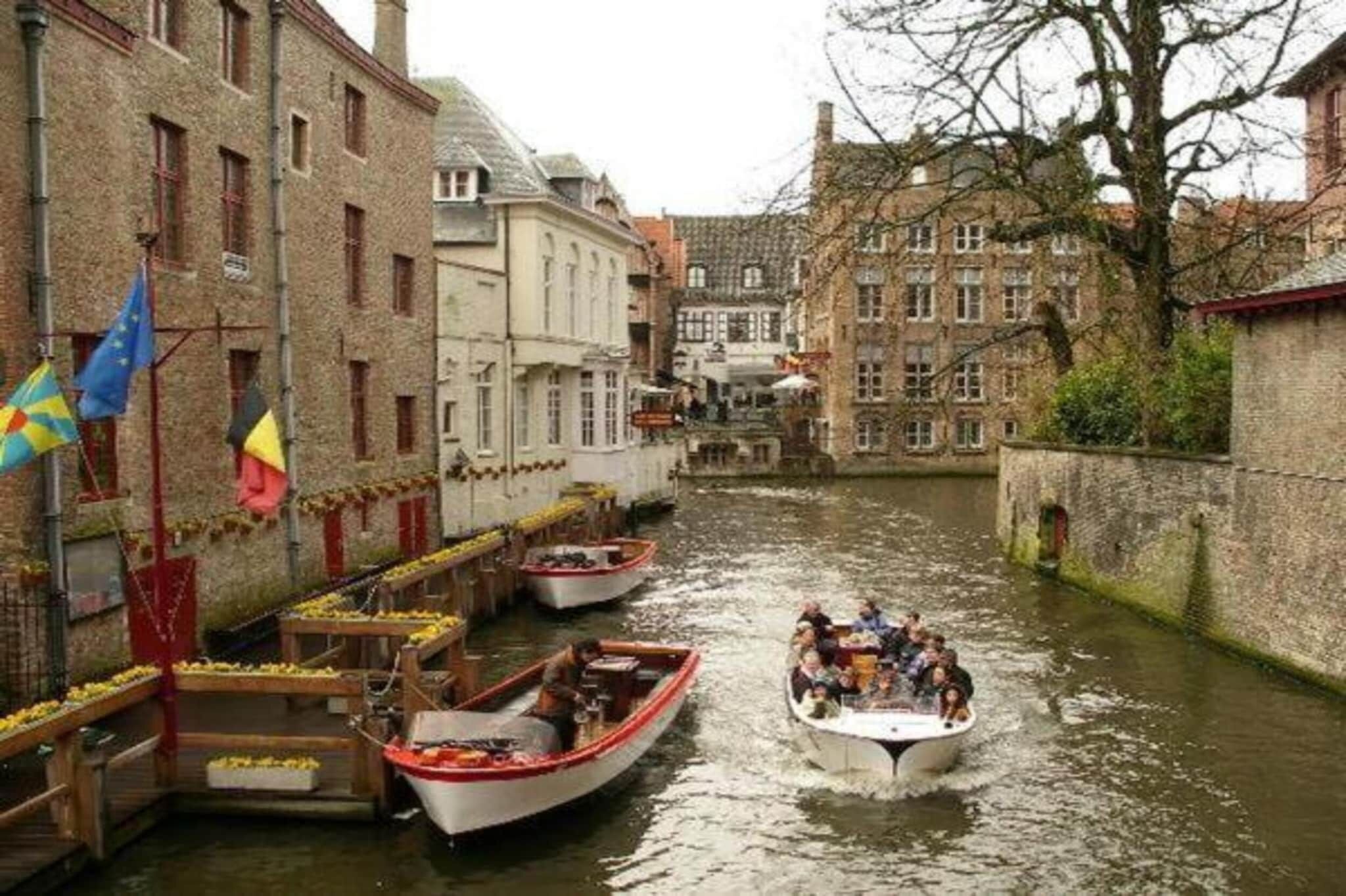 Un canal étroit, bordé de bateaux et d’immeubles.