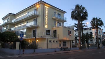 Un hotel de varios pisos con balcones, un cartel que indica que es un hotel y una señal de no estacionamiento.