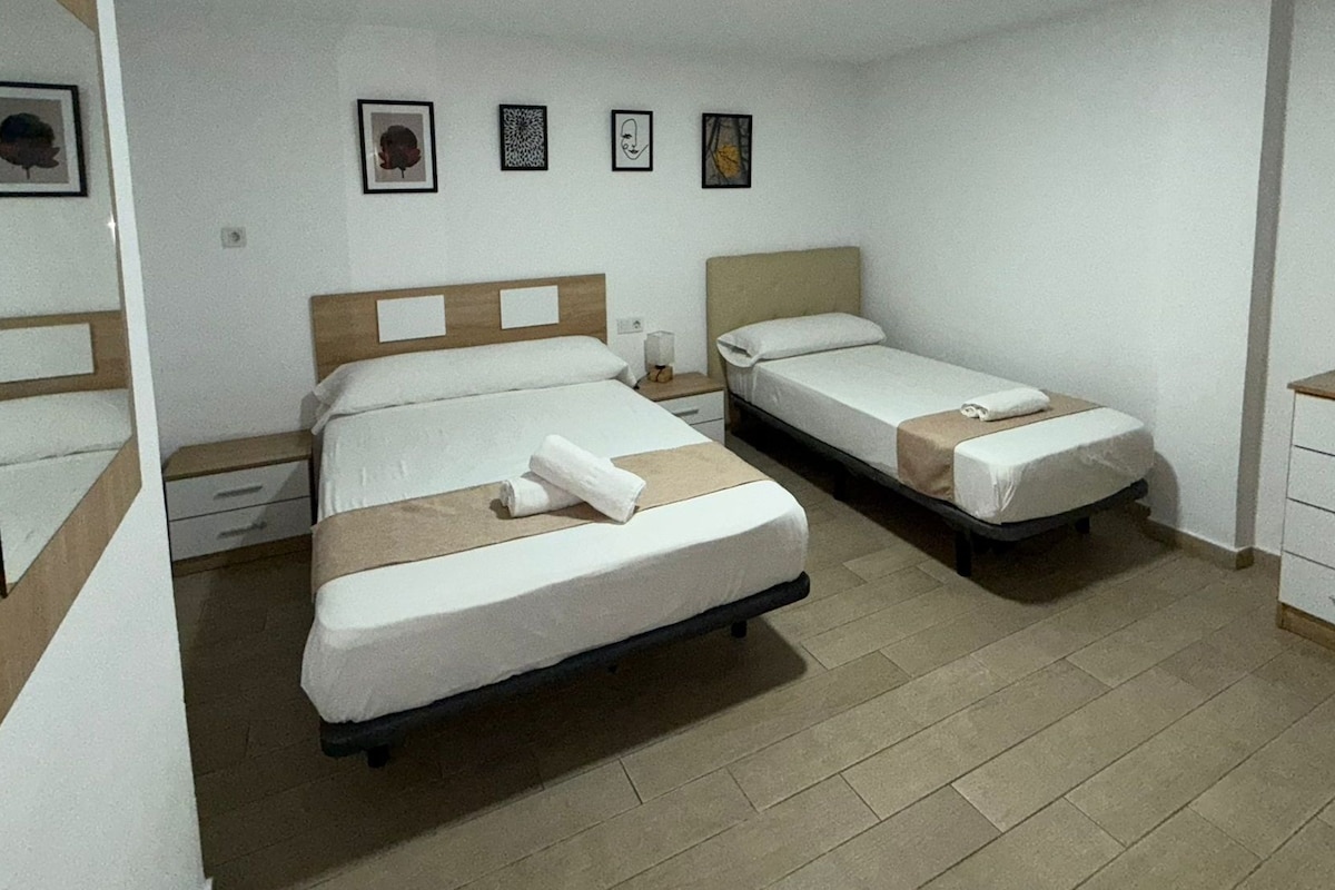 A room with two beds and a shared bathroom.