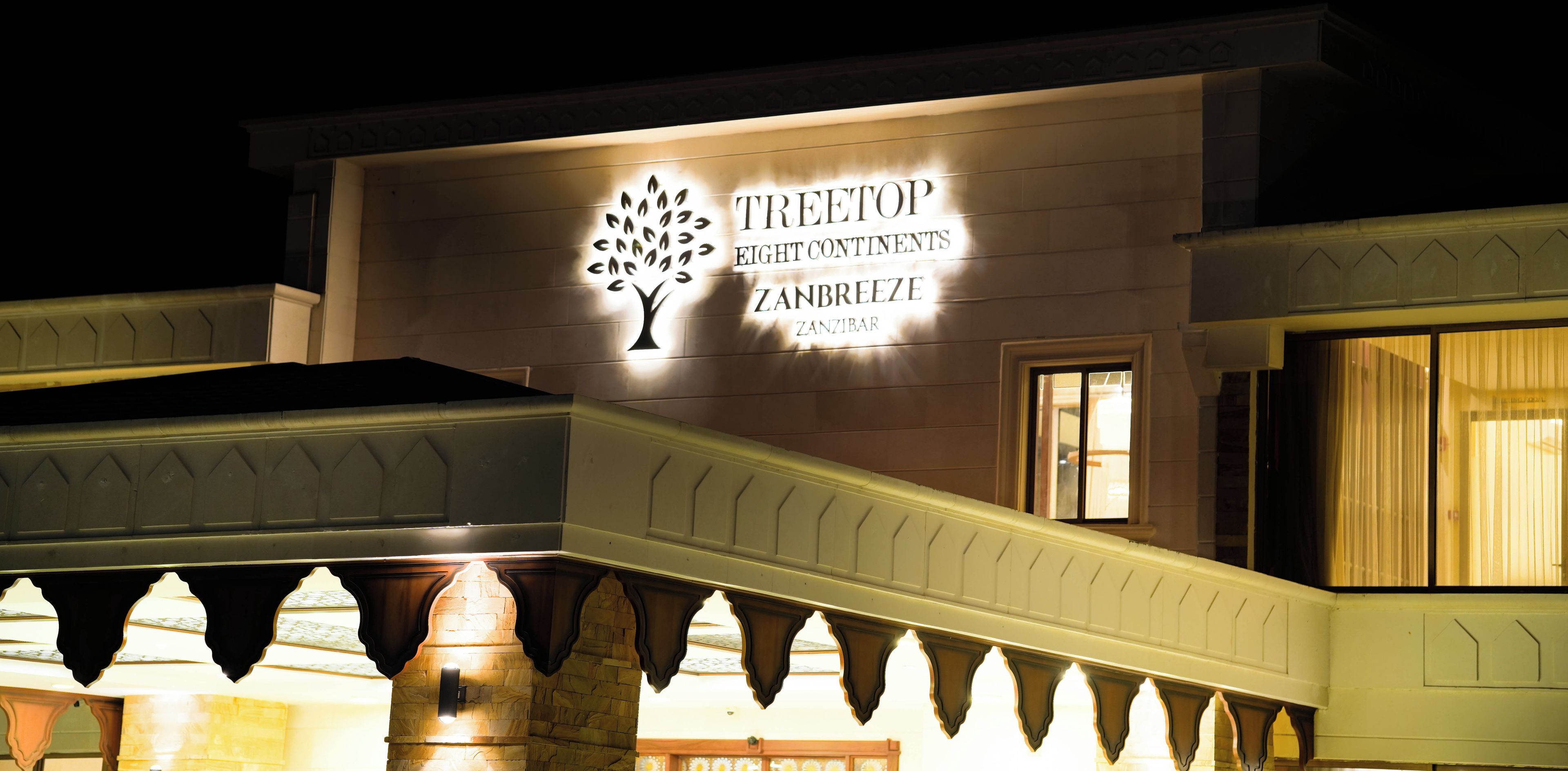 A building with a sign that reads "TREETOP EIGHT CONTINENTS ZANBREEZE ZANZIBAR".