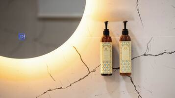 Two bottles of Eight Contients body lotion and hand wash on a cracked white surface.