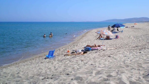 A beach with sand, water, and umbrellas. - Casa 10 Da Georgette - Affitti Brevi Italia (Valledoria)