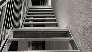 A staircase leading up to a building with a textured wall and a light fixture. - Aurora Lodge (92 m²) with Balcony and Wi-Fi (Engstingen)