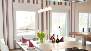 A modern kitchen with a central island, large windows, and a view of the outdoors.
