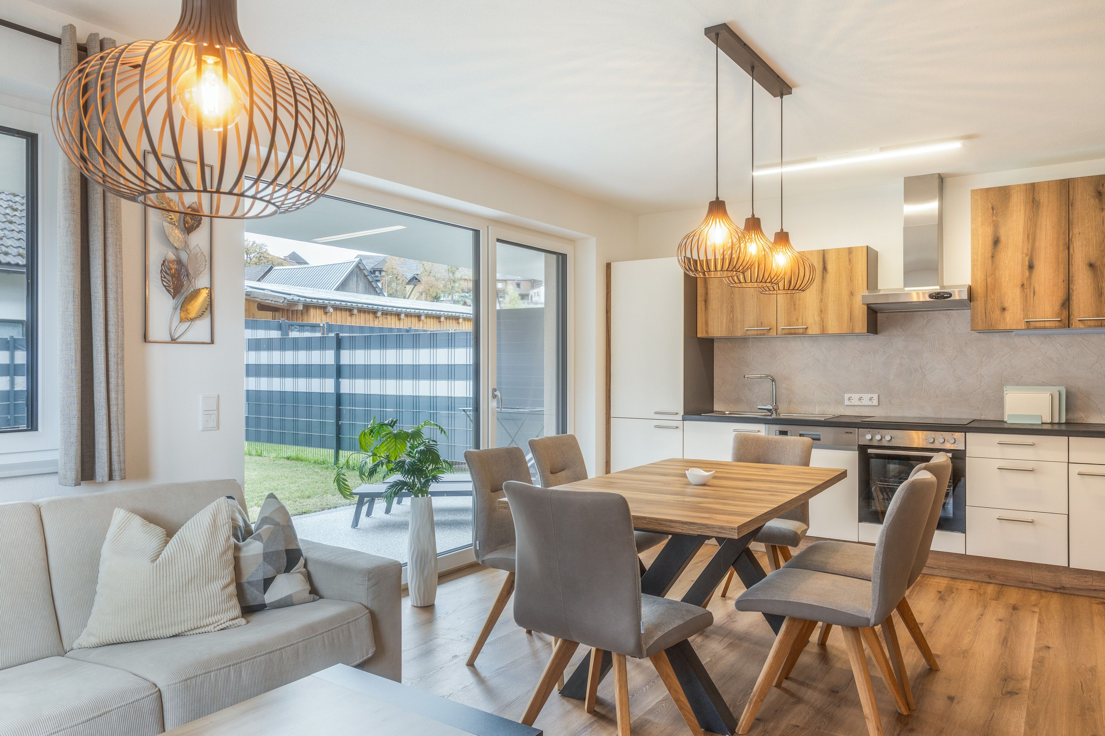 A modern kitchen with wooden cabinets, a dining table, and chairs.