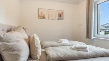 Une chambre d’hôtel avec un lit, des oreillers, une fenêtre et des œuvres d’art murales.