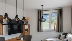 Een moderne woonkamer met een eethoek, een bank en een televisie.