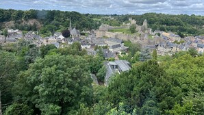 Une ville chargée d’histoire, dotée d’une architecture médiévale remarquable, avec notamment un château et une église imposants, le tout entouré d’une végétation luxuriante.