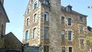 Un bâtiment historique en pierre, doté de nombreuses fenêtres et d’une entrée centrale.