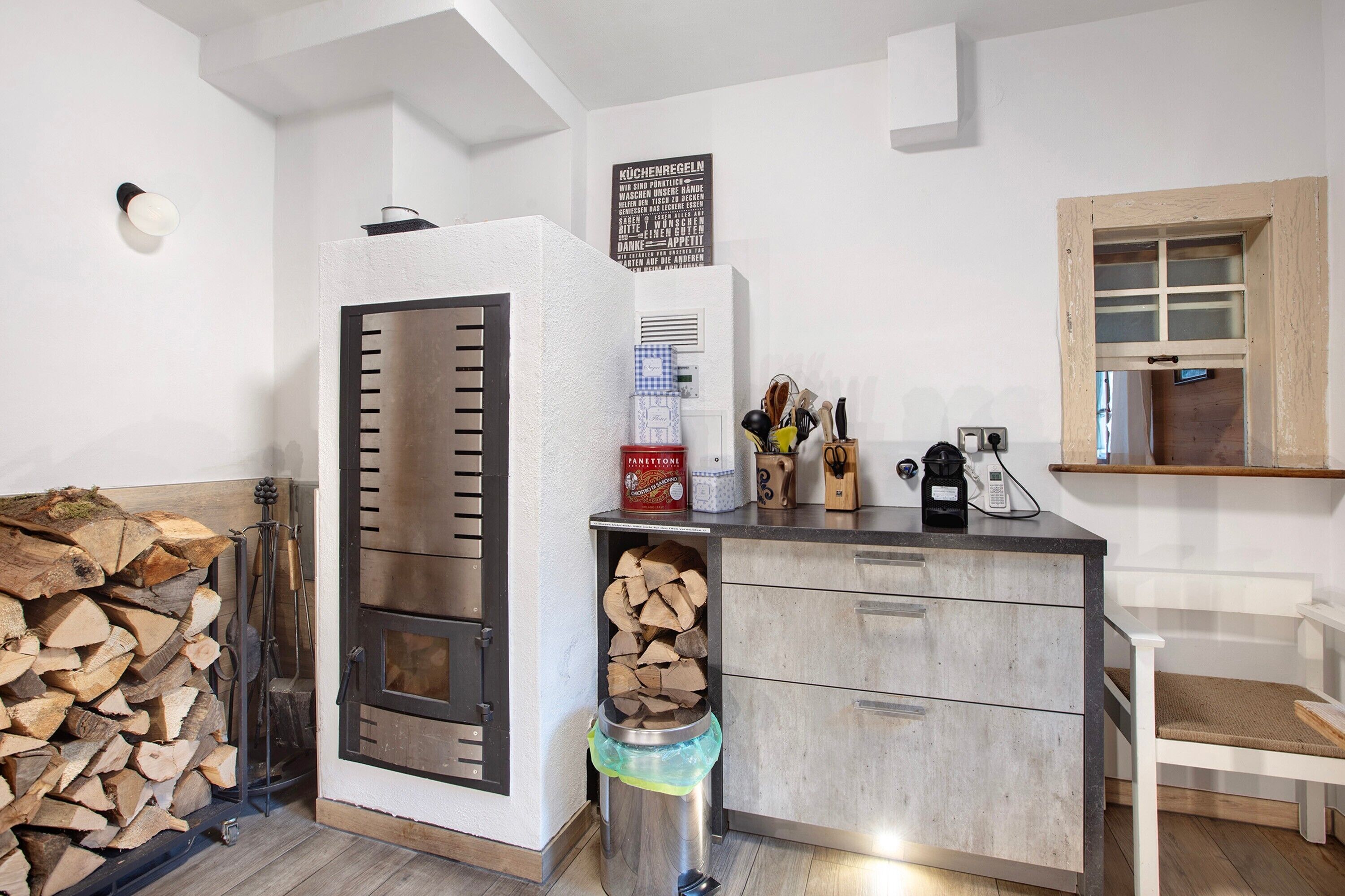 Una cucina con un camino a legna, una macchina da caffè e una finestra vista.