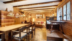 Un interior de madera con una mesa de comedor, sillas, un sofá y un banco de madera.