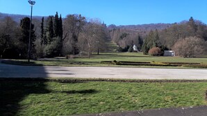A park with a pathway, trees, and a building with a dome.