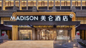 A hotel entrance with a modern facade, illuminated signage, and a staircase leading to the entrance. - xadytdtbycmljd (Xi'an)