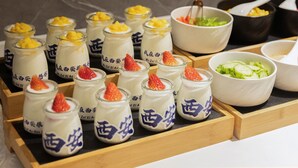 A tray of small jars with a white substance topped with fruit, accompanied by bowls of salad and soup. - xadytdtbycmljd (Xi'an)