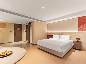 A modern hotel room with a large bed, a bedside table, a fruit bowl, and a mirror. - xadytdtbycmljd (Xi'an)