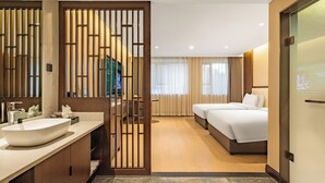 A hotel room with a large mirror, a sink, a bed, and a television. - xadytdtbycmljd (Xi'an)
