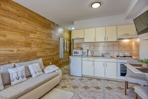 A modern kitchen with white cabinets, a built-in microwave, and a coffee maker. - Apartment Jakara (Medulin)