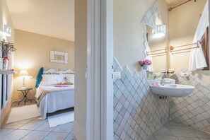 A bedroom with a bed, bedside table, lamp, and a wall-mounted picture. - Dimora Apartments (Arzachena)