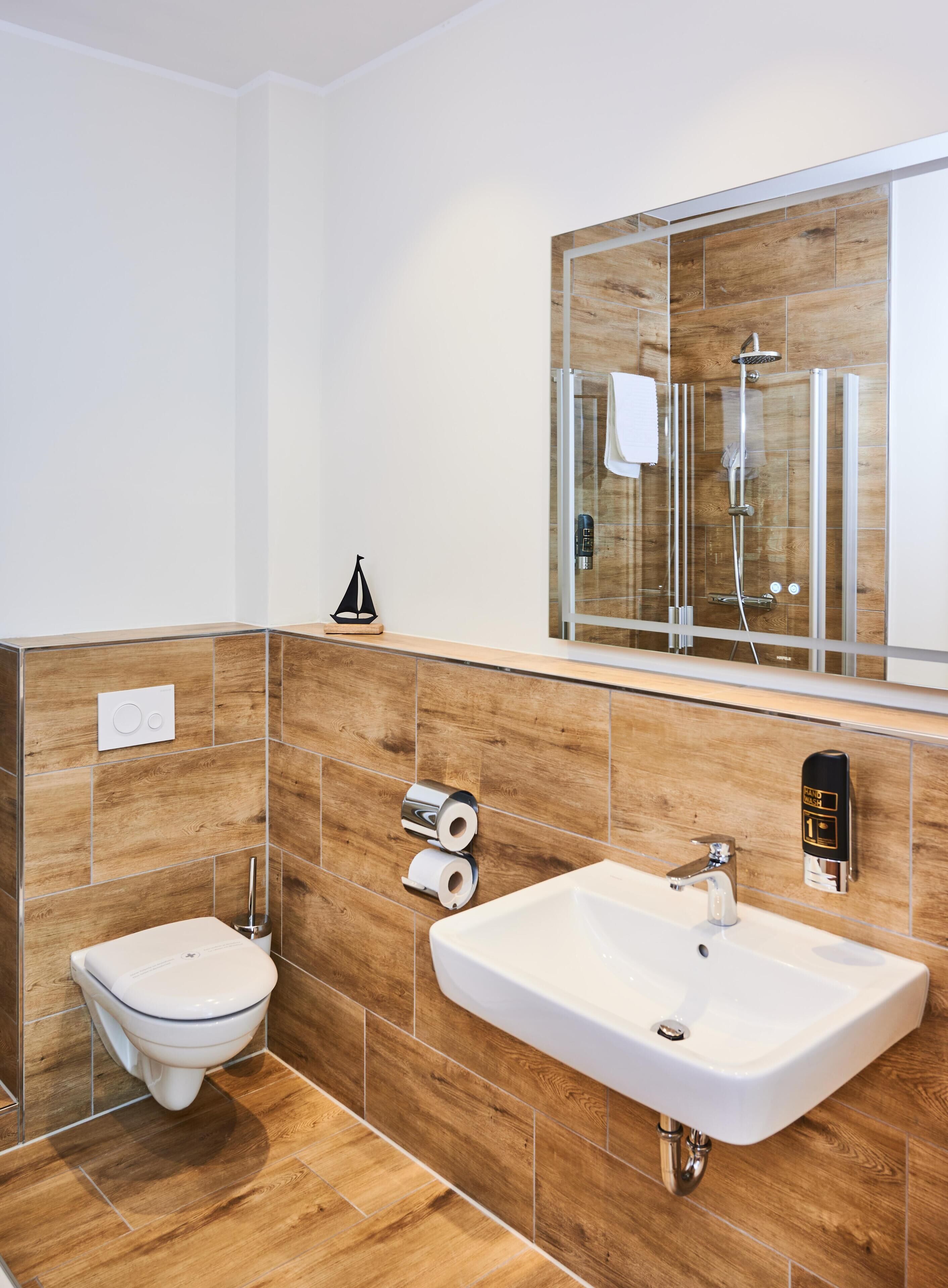 A modern bathroom with a toilet, sink, and shower.