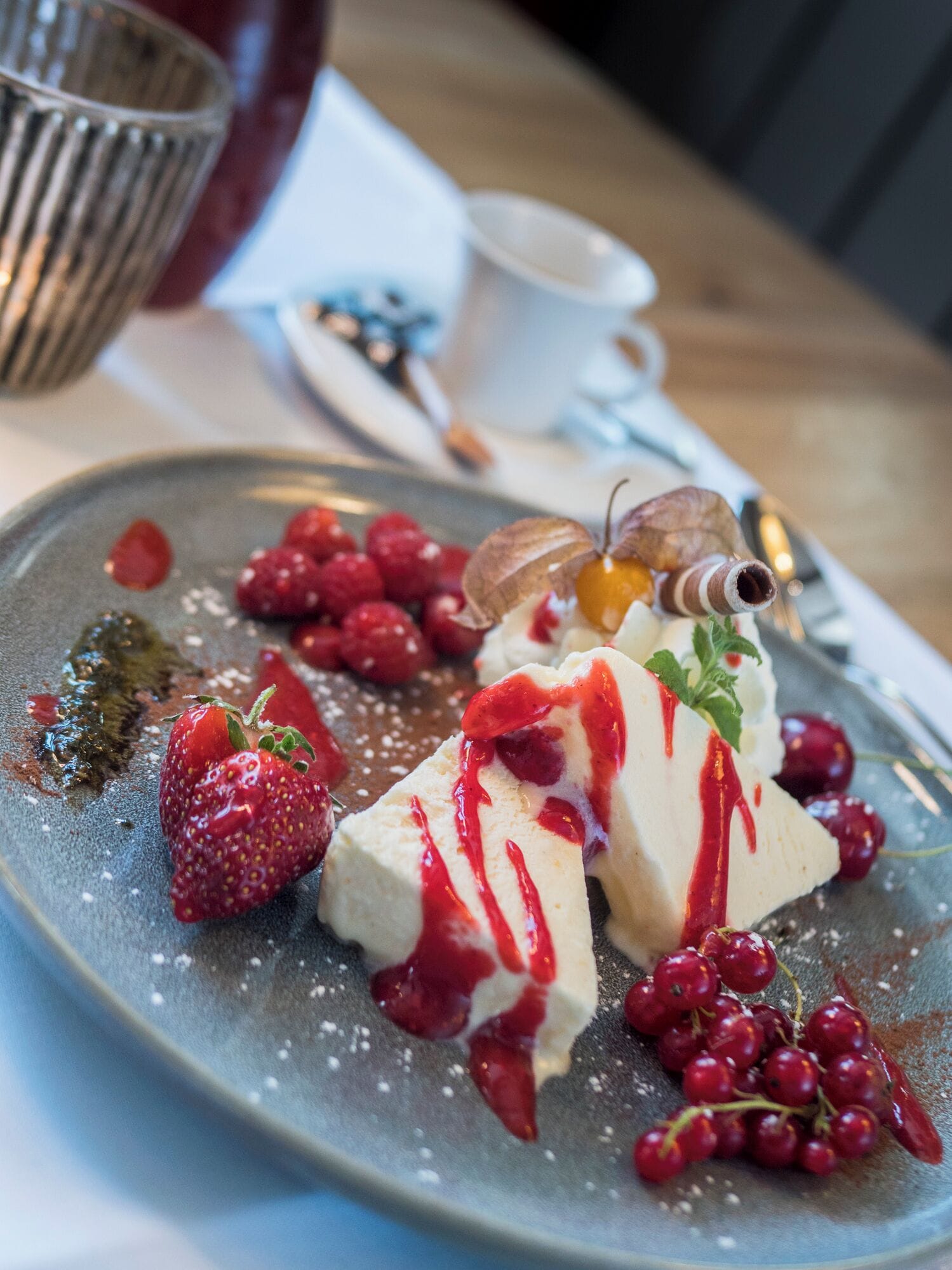 A dessert plate with strawberries, raspberries, and red currants on a ceramic plate.