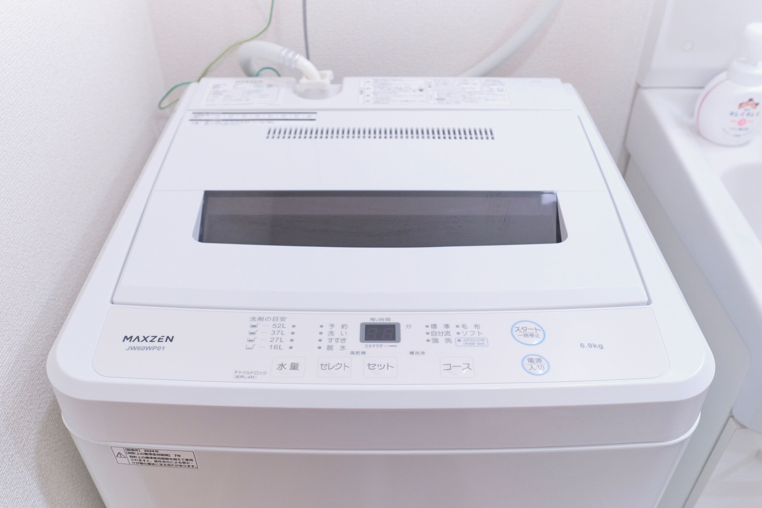 A white, compact, portable device with Japanese text, a digital display, and a small control panel.