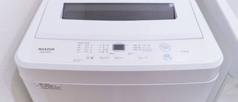 A white, compact, portable device with Japanese text, a digital display, and a small control panel.