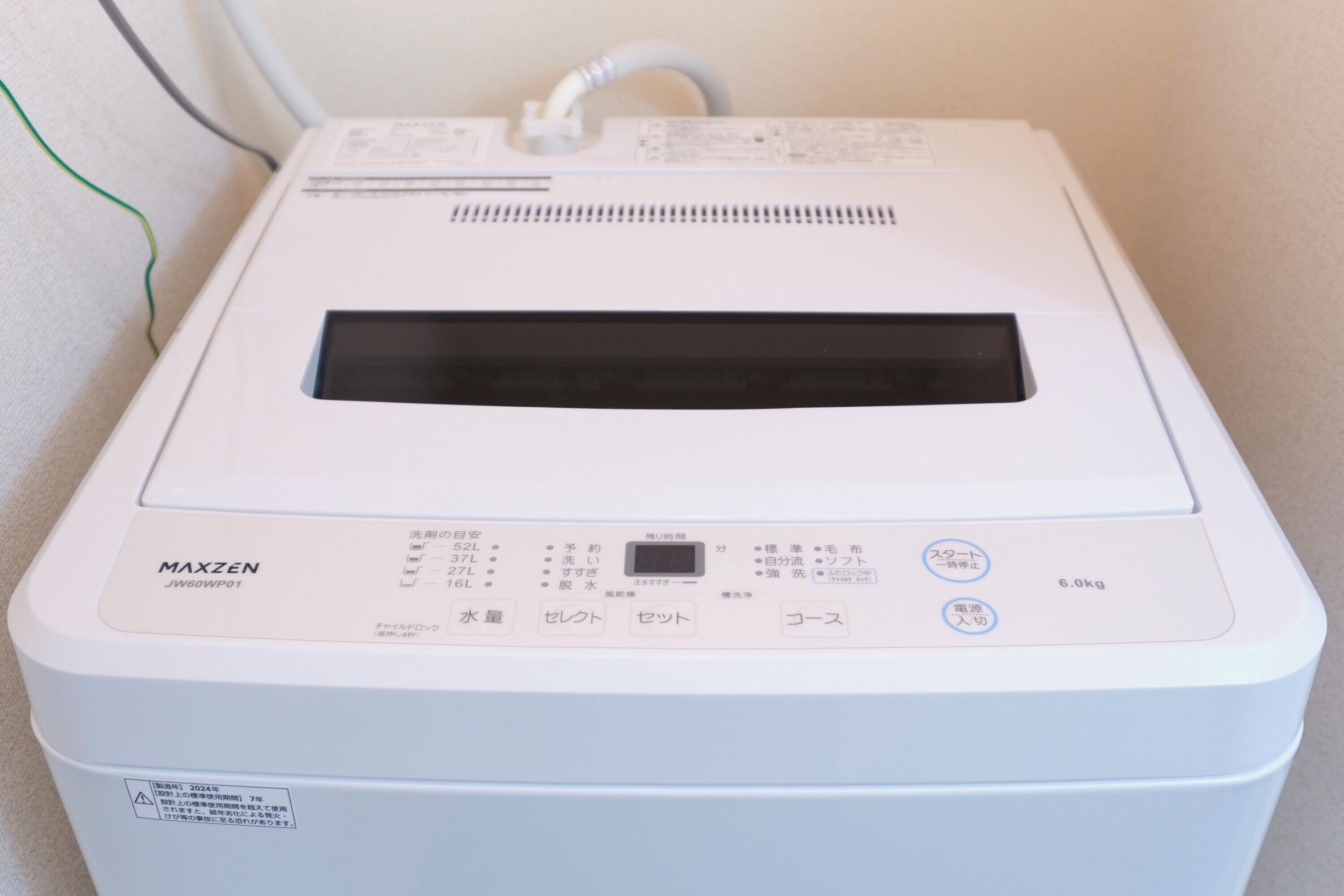 A white Maxzen JW60WP01 appliance with a control panel, a display screen, and a label indicating a weight capacity of 6.0kg.