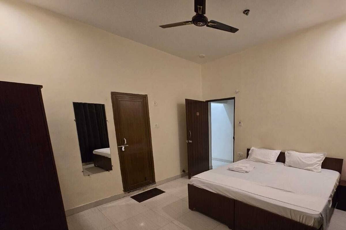 A bedroom with a bed, a ceiling fan, and two doors.