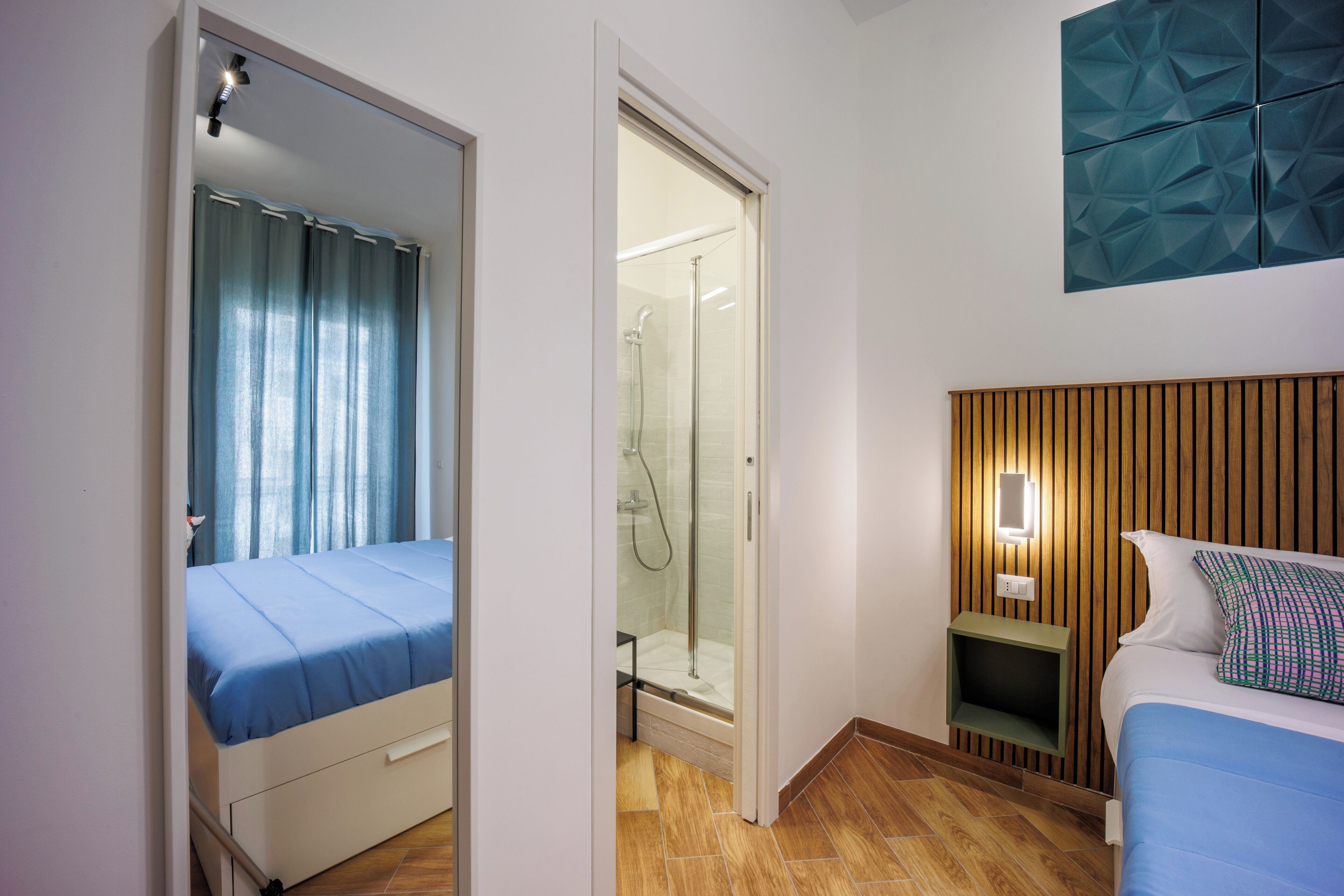 Una camera da letto con un letto, una doccia e un punto luce a parete.