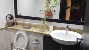 A modern bathroom with a toilet, sink, and mirror.