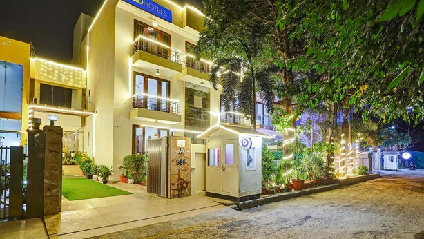 A hotel with a modern design, featuring a prominent '1abHOTELS' sign, a well-lit entrance, and a lush green garden area. - Fabhotel B Stays (Gurugram)