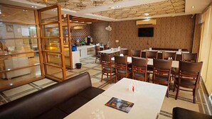 Um restaurante com área de cabines, mesas e bar.