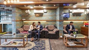 A lobby with leather sofas, a glass coffee table, and a television on the wall. - FabHotel I Residency - Koramangala (Nr St. John's Hospital) (Bengaluru)