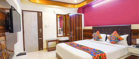 A modern hotel room with a large bed, a bedside table, a wardrobe, and a television.
