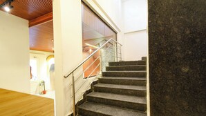 A staircase with metal railings leading to a wooden ceiling. - Fabhotel White Ridge (Hyderabad)
