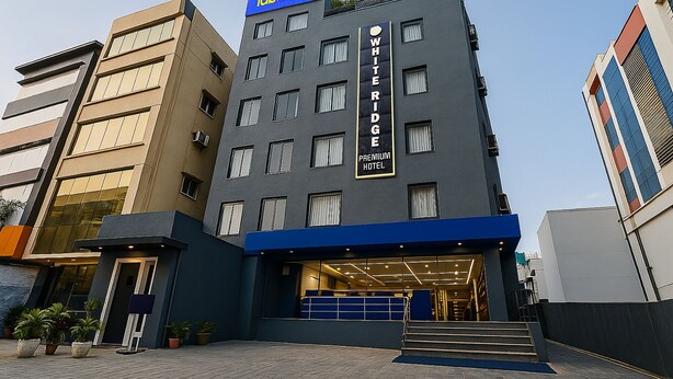 A modern hotel with a prominent "White Ridge Premium Hotel" sign, featuring a blue and grey facade, and a visible entrance with steps leading up to the door. - Fabhotel White Ridge (Hyderabad)