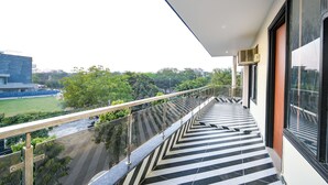 A modern building with a balcony featuring a black and white striped floor. - FabHotel RR Premium (Gurugram)