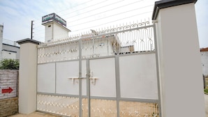 A gated entrance with a metal fence and a sign above it. - Fabhotel Jayaditya Palace (Ayodhya)