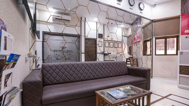 Una sala de estar moderna con un sofá de cuero marrón, una mesa de centro de madera y una pared con patrón hexagonal.
