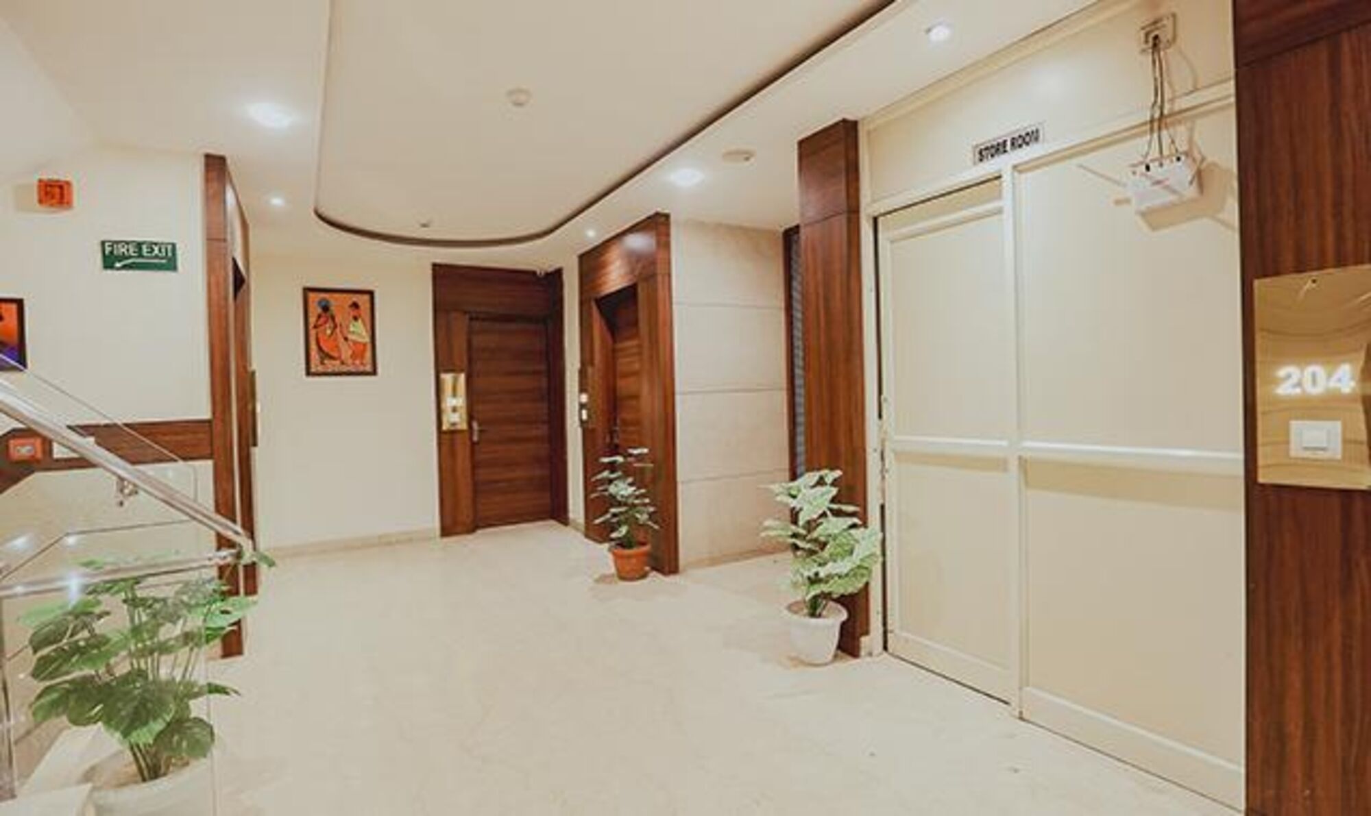 Un hall d’hôtel avec un panneau indiquant la sortie de secours, un escalier et un local de stockage.