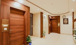 Eine Hotellobby mit Holztüren, einer Uhr und einem Blumentopf.