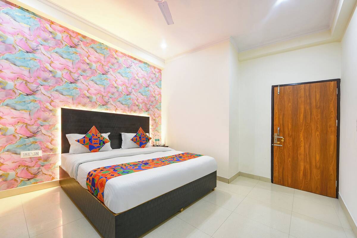 Un dormitorio moderno con cama, armario de madera y pared con diseño de mármol.