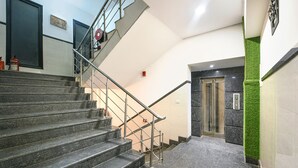A staircase with metal railings leading to an elevator. - Fabhotel Vivaah Inn (New Delhi)
